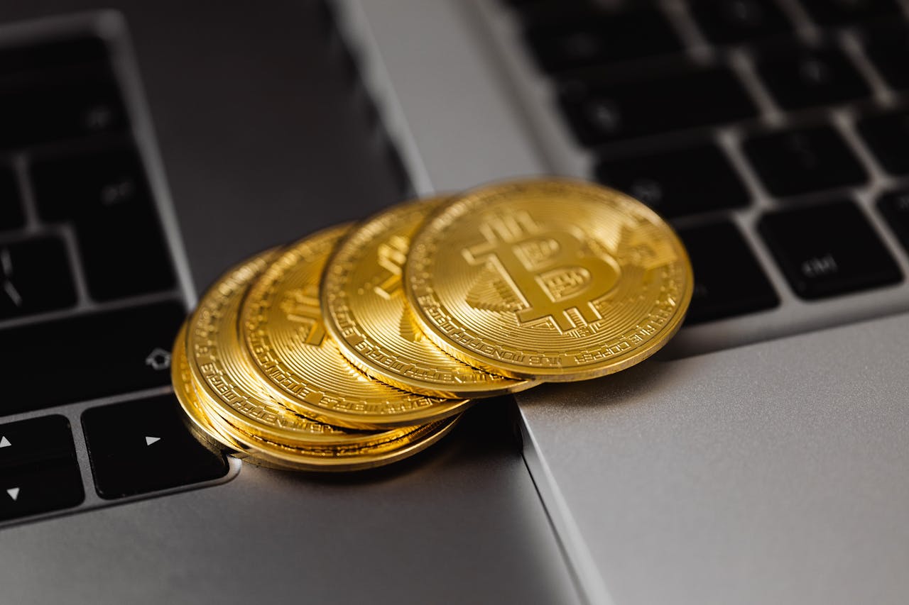 Close-up of golden bitcoins on a laptop keyboard representing digital currency and wealth.